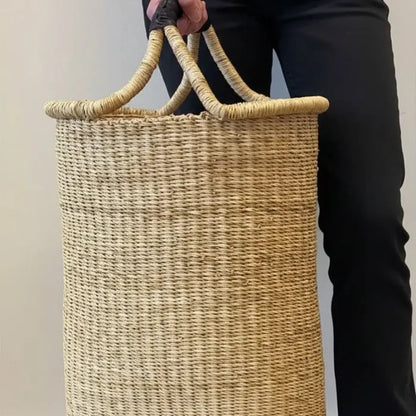 Person holding a woven basket with a plain background