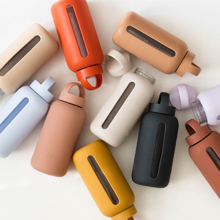 A collection of multicolored Hydration Tracking Glass Water Bottles